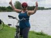 A woman is happy and giving 2 thumbs up to Escape Tours and rentals during her bike tour in Ottawa at Ottawa river pathway