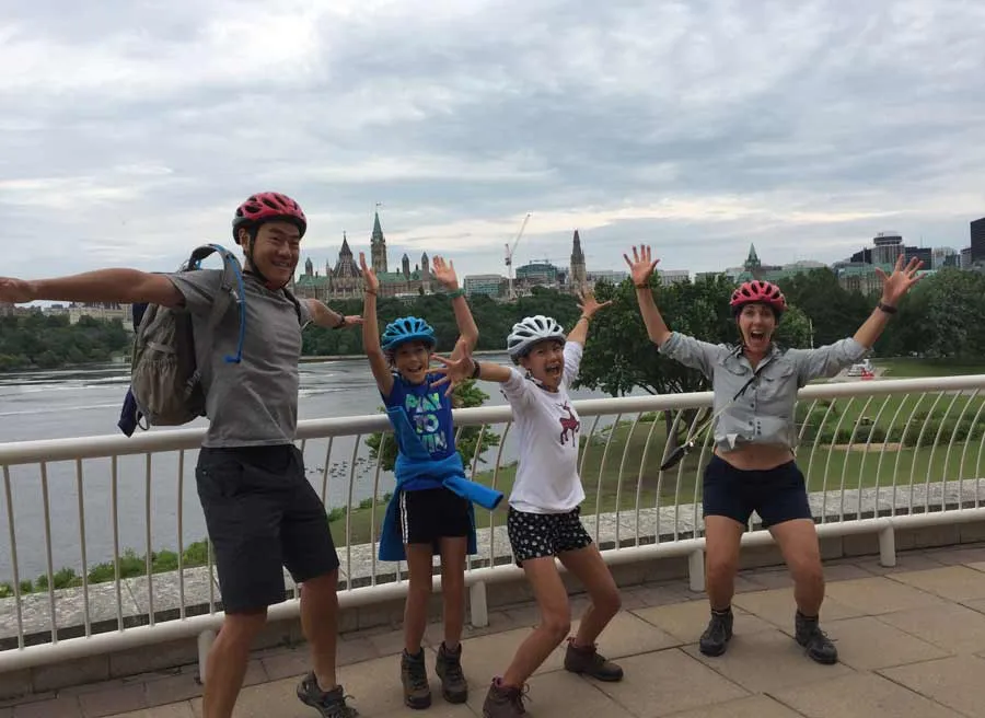 Family is happy at the Museum of History lookout at with a view of Parliament building on an Ottawa express bike tour