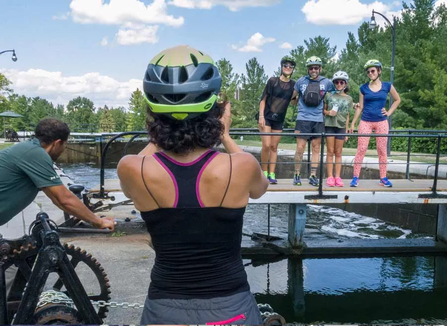 Mom is taking a picture of family at Hartwells Lock of Rideau Canal during express tour by bike with Escape Tours Rentals in Ottawa